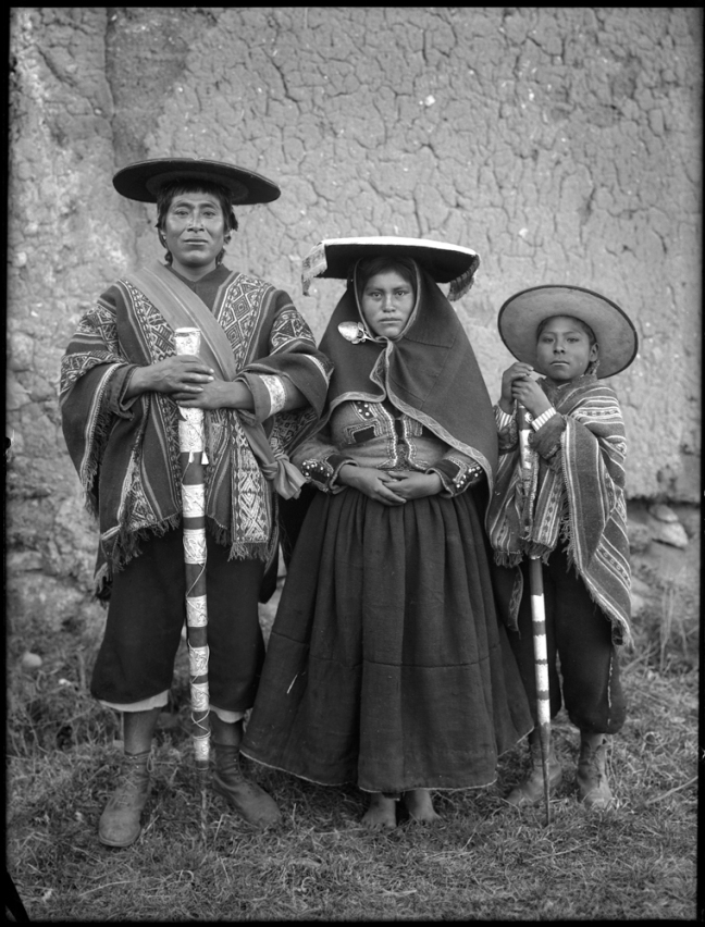 Quechuan man, woman, and child holding traditional walking sticks