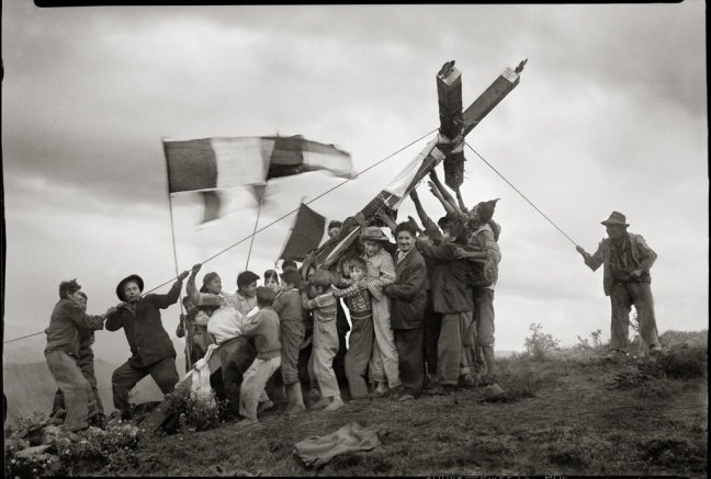 Quechuan men are erecting a large cross for teh "Fiesta de la cruz" (Festival of the cross)