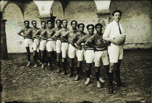 Quechuan male sports team. One of them holds a futbal