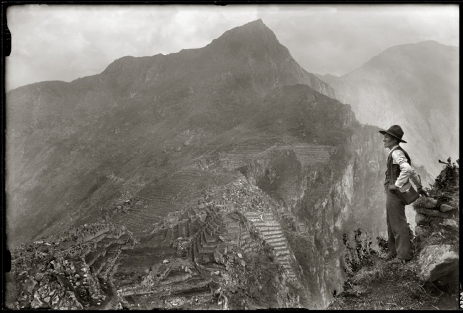 A Quechuan man stands to the side of the Hyana Picchu mountains