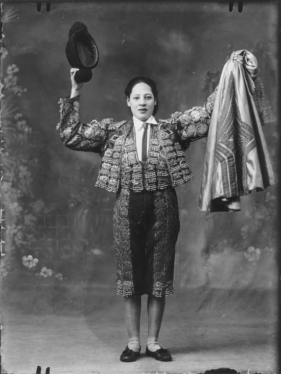 Matadora - a Spanish woman is dressed as a matador. She holds her cloak in the air