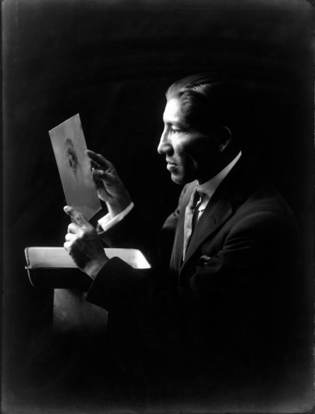 The photographer, Martin Chambi holds a portrait. He is a Quechuan man dressed in a modern suit in the early 1900s