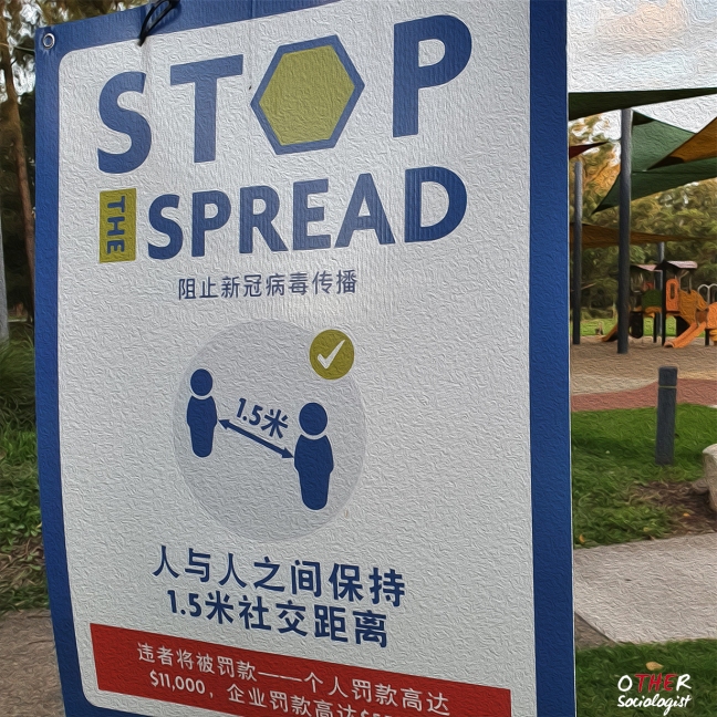 Sign saying 'stop the spread' with Chinese writing. In a background is a playground
