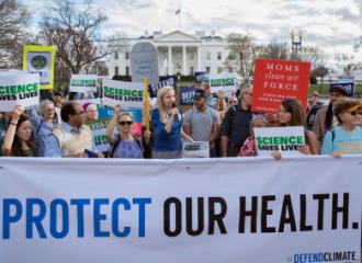 Protesters at a rally holding signs promoting science 