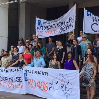 People stand in front of pro-choice banners outside Northern Territory Parliament