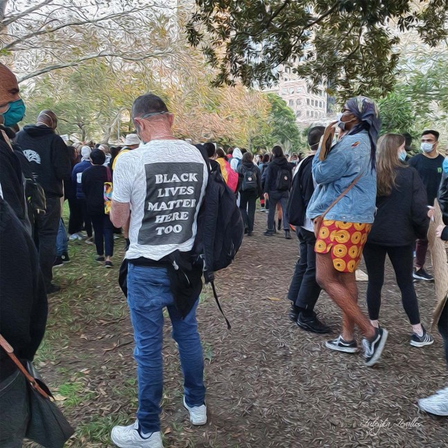 Protesters wear masks at Hyde Park in Sydney. One man's t-shirt reads: Black Lives Matter Here Too