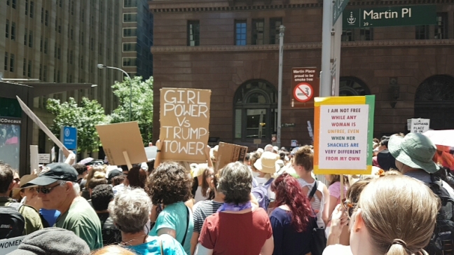 White woman holds a sign with an Audre Lorde quote that reads: "I am not free while any woman is unfree, even when her shackles are very different from my own."